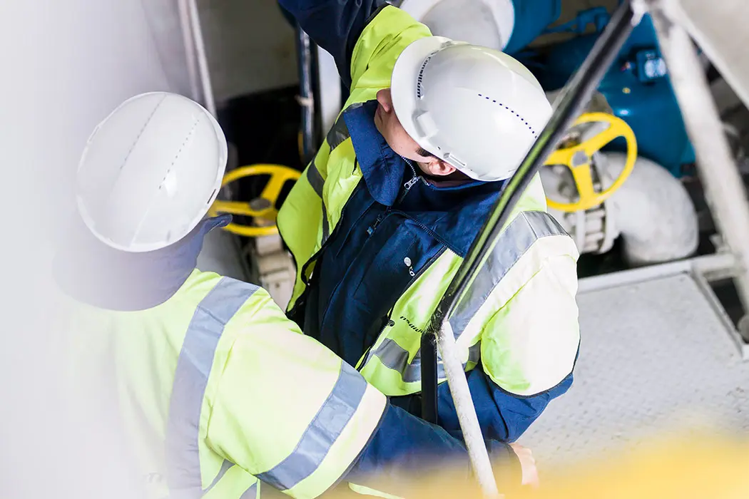 Two engineers at Consilium discussing the installation of a fire detector